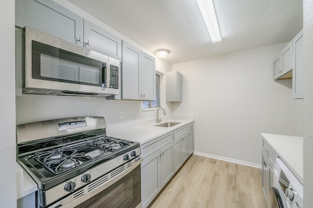 11063 Vailview Dr, Houston, TX 77016 - kitchen featuring stainless steel appliances, a sink, light wood-type flooring, light countertops, and baseboards