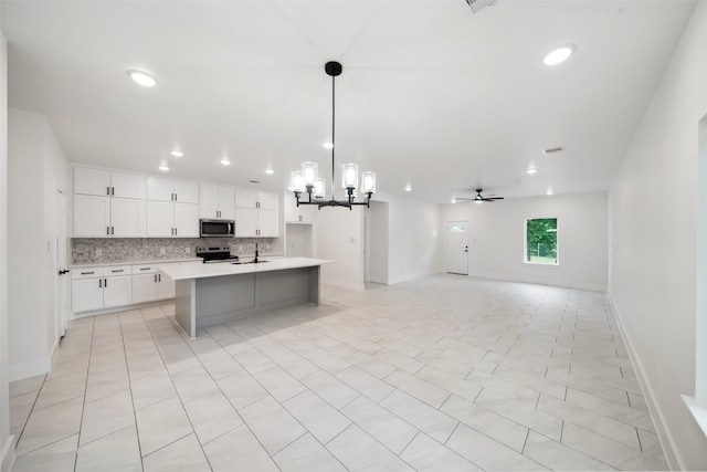 708 Azalea St, Prairie View, TX 77484 - kitchen featuring stainless steel microwave, range with electric stovetop, a chandelier, light countertops, and backsplash
