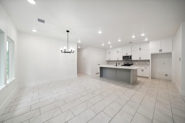 708 Azalea St, Prairie View, TX 77484 - kitchen with stainless steel microwave, a sink, light countertops, a chandelier, and range with electric cooktop