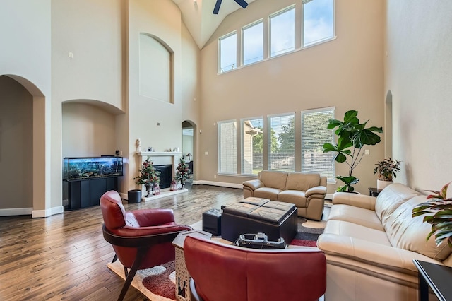 7203 Prairie Grass Ln, Katy, TX 77493 - living area featuring high vaulted ceiling, hardwood / wood-style flooring, ceiling fan, arched walkways, and baseboards