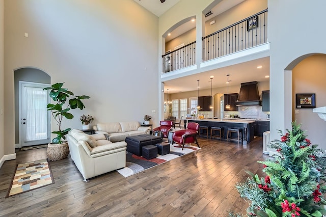 7203 Prairie Grass Ln, Katy, TX 77493 - living area with a towering ceiling, dark wood-style floors, arched walkways, and baseboards