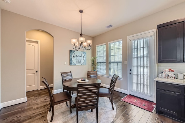 7203 Prairie Grass Ln, Katy, TX 77493 - dining space featuring wood finished floors, baseboards, a chandelier, and arched walkways
