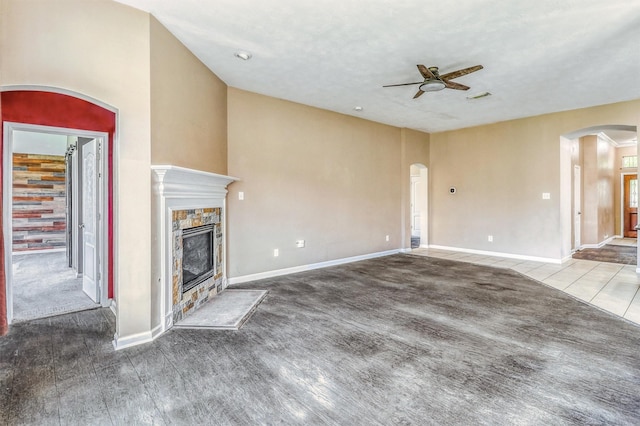 7523 Chathan Glen Ln, Richmond, TX 77407 - unfurnished living room with ceiling fan, arched walkways, a stone fireplace, baseboards, and carpet flooring