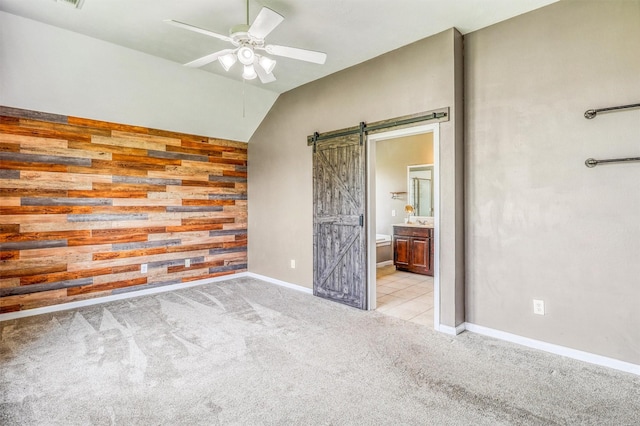 7523 Chathan Glen Ln, Richmond, TX 77407 - unfurnished bedroom with a barn door, carpet flooring, ensuite bathroom, baseboards, and lofted ceiling