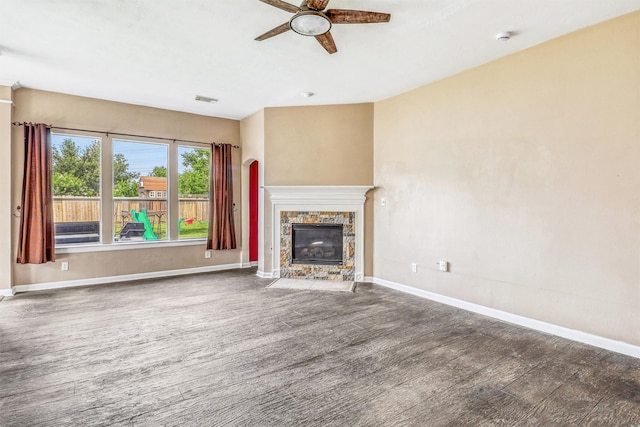 7523 Chathan Glen Ln, Richmond, TX 77407 - unfurnished living room featuring ceiling fan, a stone fireplace, wood finished floors, and baseboards