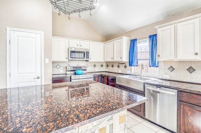 7523 Chathan Glen Ln, Richmond, TX 77407 - kitchen featuring appliances with stainless steel finishes, a sink, white cabinets, vaulted ceiling, and decorative backsplash