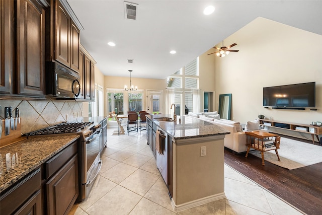 1406 Kallie Hills Ln, Spring, TX 77386 - kitchen featuring appliances with stainless steel finishes, a sink, a chandelier, ceiling fan, and dark stone counters