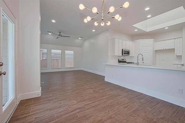 4046 Dell Ln, Missouri City, TX 77459 - kitchen featuring appliances with stainless steel finishes, wood finished floors, a ceiling fan, white cabinets, and lofted ceiling