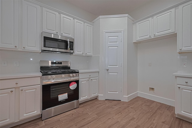 4046 Dell Ln, Missouri City, TX 77459 - kitchen with appliances with stainless steel finishes, light countertops, white cabinets, and light wood finished floors