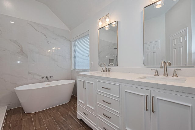 4046 Dell Ln, Missouri City, TX 77459 - full bathroom featuring double vanity, a freestanding tub, vaulted ceiling, and wood tiled floors
