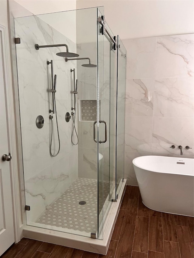 4046 Dell Ln, Missouri City, TX 77459 - bathroom featuring wood tiled floors, a shower stall, a freestanding bath, and tile walls