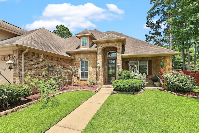 18 Brookefield Cir, Magnolia, TX 77355 - view of front of house featuring stone siding, a front yard, and roof with shingles