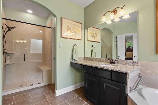 18 Brookefield Cir, Magnolia, TX 77355 - bathroom featuring a shower stall, tile patterned flooring, vanity, a bath, and baseboards