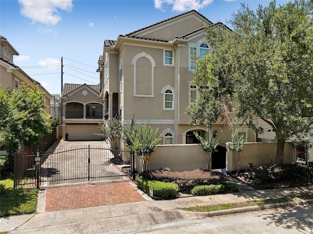 5507 Val Verde St, Houston, TX 77056 - view of front of home featuring stucco siding, decorative driveway, a garage, a fenced front yard, and a gate
