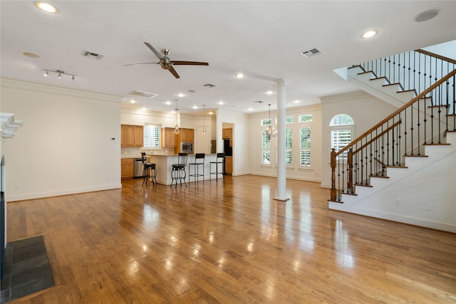 5507 Val Verde St, Houston, TX 77056 - living area featuring crown molding, ceiling fan, ornate columns, recessed lighting, and stairway