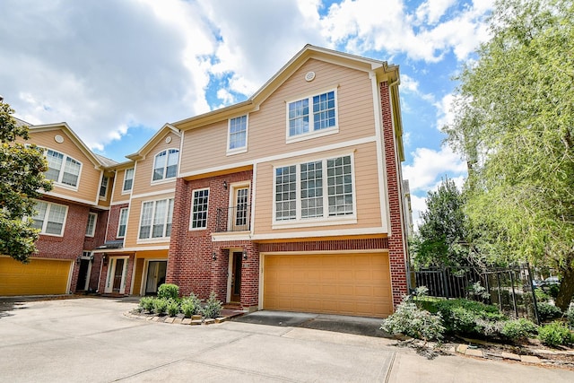 902 Cohn St, Houston, TX 77007 - view of property featuring asphalt driveway, an attached garage, and brick siding