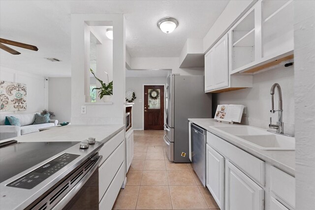11731 Bexar Dr, La Porte, TX 77571 - kitchen with stainless steel appliances, white cabinetry, and light countertops
