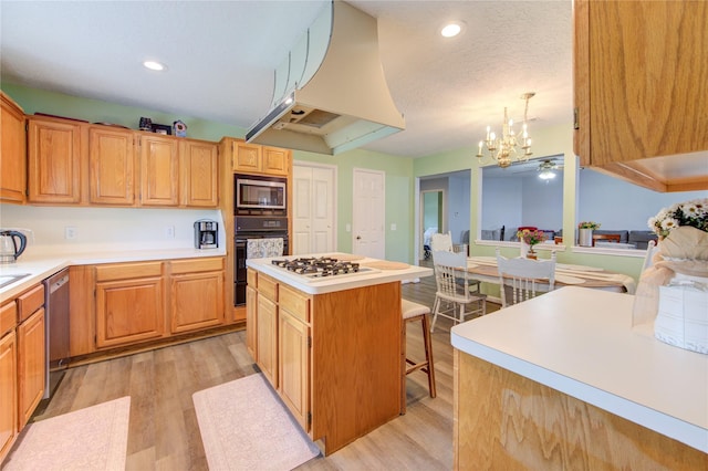 3402 Deeds Rd, Houston, TX 77084 - kitchen with light wood-style floors, appliances with stainless steel finishes, custom exhaust hood, a chandelier, and light countertops