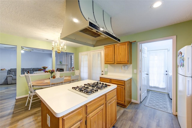 3402 Deeds Rd, Houston, TX 77084 - kitchen with white appliances, dark wood finished floors, light countertops, a chandelier, and exhaust hood