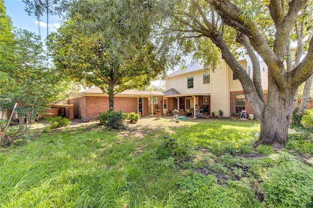 3402 Deeds Rd, Houston, TX 77084 - rear view of house featuring brick siding, a yard, and a patio area