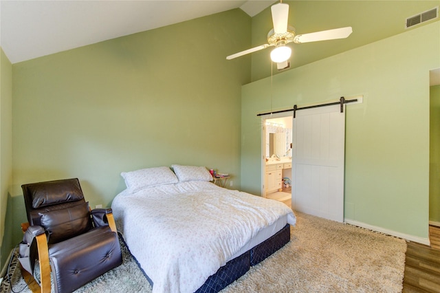 3402 Deeds Rd, Houston, TX 77084 - bedroom with a barn door, high vaulted ceiling, wood finished floors, baseboards, and ensuite bathroom