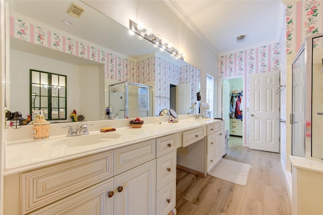 3402 Deeds Rd, Houston, TX 77084 - full bathroom featuring wallpapered walls, ornamental molding, a shower stall, double vanity, and wood finished floors