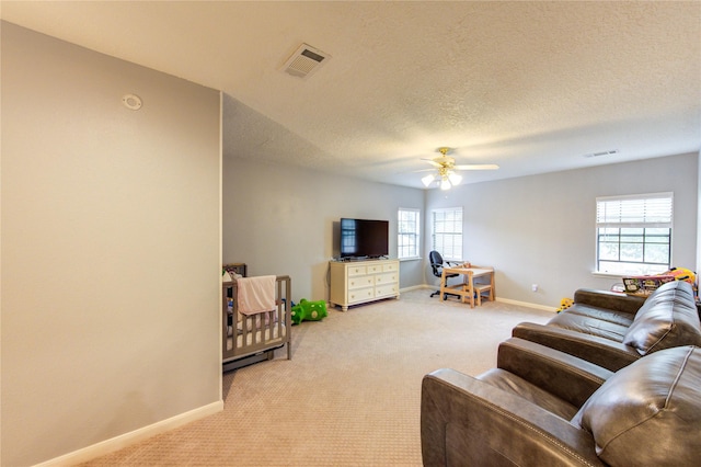 3402 Deeds Rd, Houston, TX 77084 - living room featuring light colored carpet, baseboards, a ceiling fan, and a textured ceiling