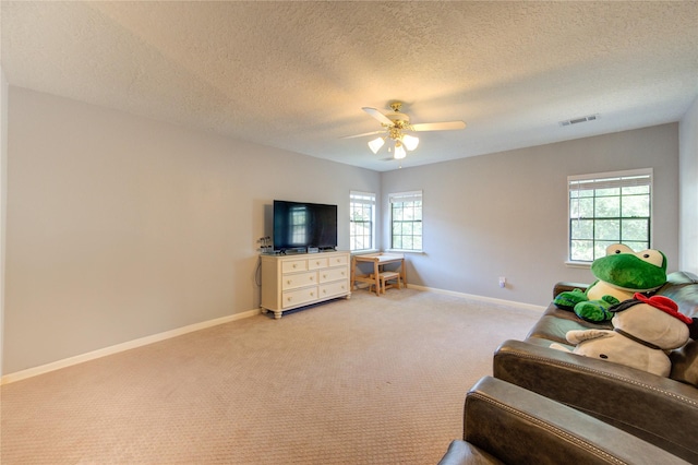 3402 Deeds Rd, Houston, TX 77084 - living area with a ceiling fan, baseboards, light colored carpet, and a textured ceiling