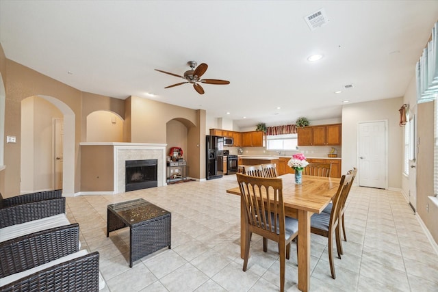 21551 Elm Hurst Ln, Katy, TX 77450 - dining area with a ceiling fan, a fireplace, light tile patterned floors, baseboards, and recessed lighting