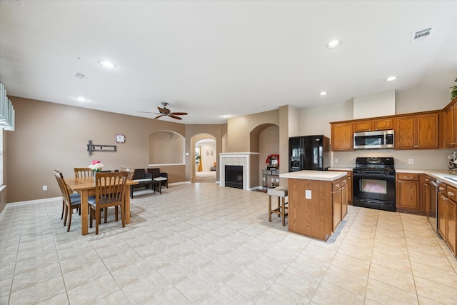 21551 Elm Hurst Ln, Katy, TX 77450 - kitchen featuring black appliances, arched walkways, light countertops, ceiling fan, and recessed lighting