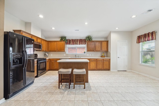 21551 Elm Hurst Ln, Katy, TX 77450 - kitchen featuring black appliances, light countertops, light tile patterned floors, brown cabinets, and recessed lighting