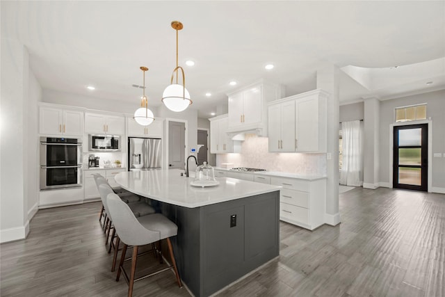 19307 Spillway Overlook Cir, Cypress, TX 77433 - kitchen with a spacious island, decorative backsplash, appliances with stainless steel finishes, white cabinetry, and recessed lighting