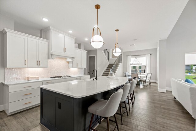 19307 Spillway Overlook Cir, Cypress, TX 77433 - kitchen featuring decorative backsplash, white cabinets, a large island with sink, light countertops, and recessed lighting