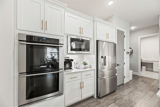 19307 Spillway Overlook Cir, Cypress, TX 77433 - kitchen with stainless steel appliances, light countertops, white cabinetry, recessed lighting, and decorative backsplash