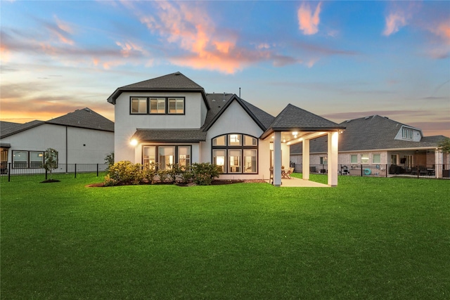 19307 Spillway Overlook Cir, Cypress, TX 77433 - back of property at dusk with stucco siding, a shingled roof, and a patio