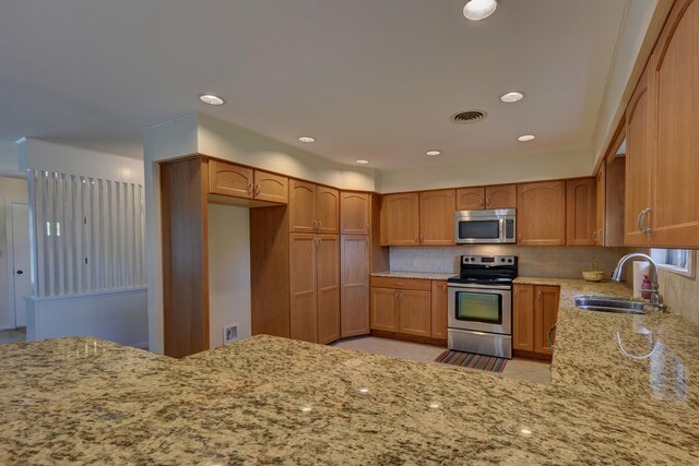 906 Carlee Dr, Brenham, TX 77833 - kitchen with stainless steel appliances, a sink, light stone countertops, decorative backsplash, and recessed lighting