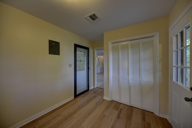 906 Carlee Dr, Brenham, TX 77833 - unfurnished bedroom with light wood finished floors, baseboards, a closet, and electric panel