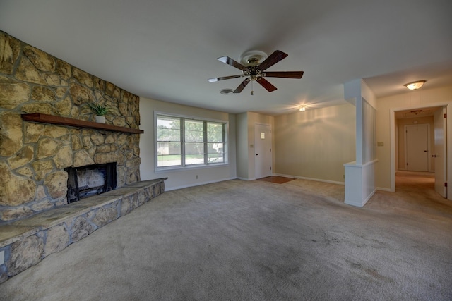 906 Carlee Dr, Brenham, TX 77833 - unfurnished living room featuring carpet, ceiling fan, a stone fireplace, and baseboards