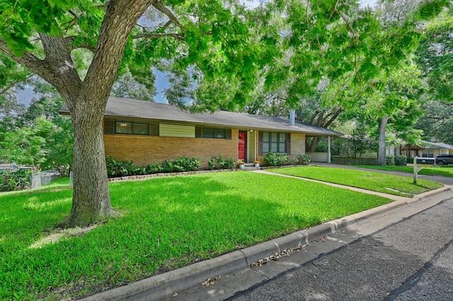 906 Carlee Dr, Brenham, TX 77833 - ranch-style house featuring brick siding, a front yard, a carport, and concrete driveway