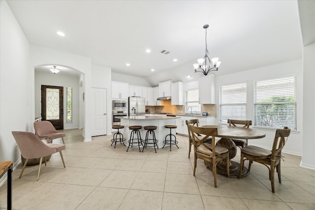 19726 Terrace Cliff Ct, Richmond, TX 77407 - dining space with arched walkways, lofted ceiling, light tile patterned floors, baseboards, and a chandelier