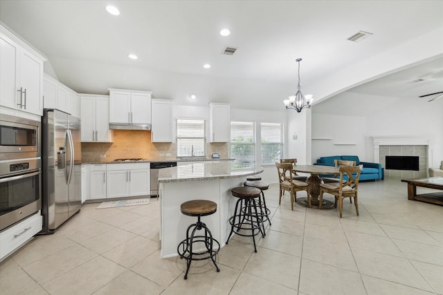 19726 Terrace Cliff Ct, Richmond, TX 77407 - kitchen featuring stainless steel appliances, light tile patterned floors, a chandelier, tasteful backsplash, and recessed lighting