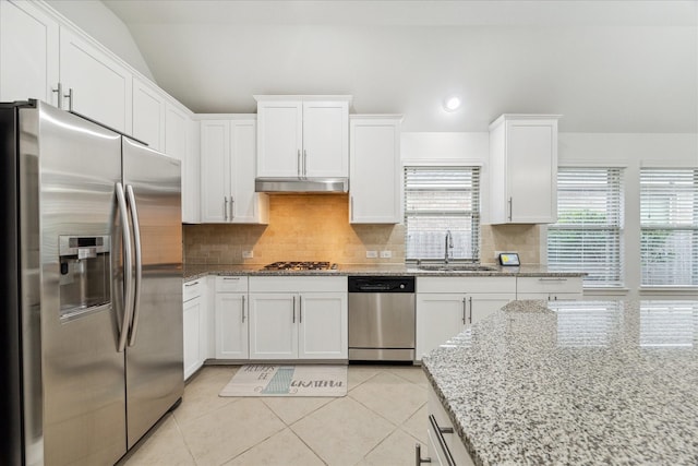 19726 Terrace Cliff Ct, Richmond, TX 77407 - kitchen with appliances with stainless steel finishes, a sink, lofted ceiling, white cabinetry, and decorative backsplash