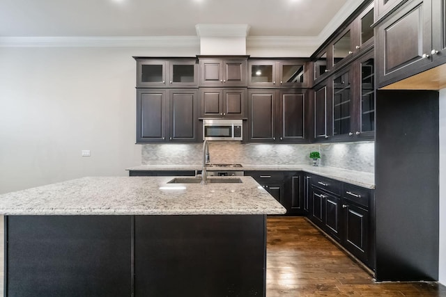1811 Upland Lks, Houston, TX 77043 - kitchen featuring stainless steel microwave, a sink, ornamental molding, an island with sink, and tasteful backsplash