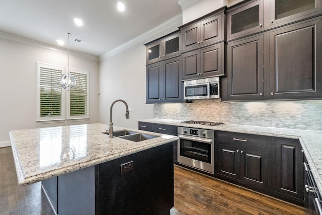 1811 Upland Lks, Houston, TX 77043 - kitchen featuring appliances with stainless steel finishes, a sink, dark wood-type flooring, ornamental molding, and an island with sink