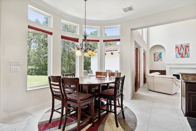 19 Shields Ln, Montgomery, TX 77356 - dining room featuring a chandelier, ornamental molding, light tile patterned floors, a fireplace, and a towering ceiling