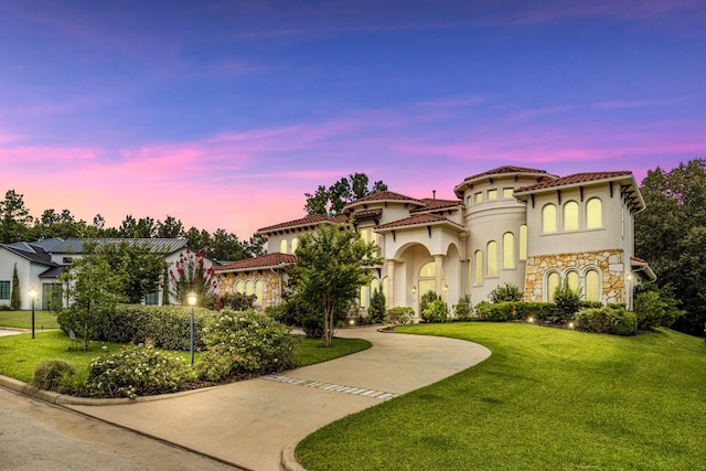 19 Shields Ln, Montgomery, TX 77356 - mediterranean / spanish home featuring curved driveway, a front yard, stucco siding, and stone siding