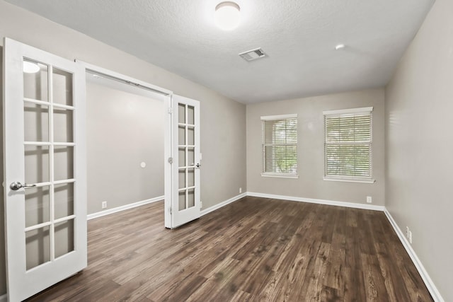 4522 Woodspring Glen Ln, Houston, TX 77345 - spare room with french doors, dark wood-type flooring, baseboards, and a textured ceiling