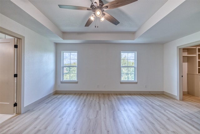 6 Rio Seco Dr, Uvalde, TX 78801 - unfurnished bedroom featuring a tray ceiling, light wood finished floors, and a ceiling fan