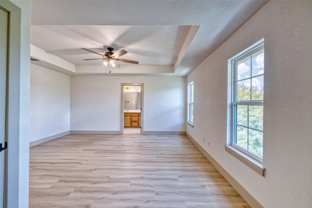 6 Rio Seco Dr, Uvalde, TX 78801 - spare room with light wood-style floors, a tray ceiling, and ceiling fan