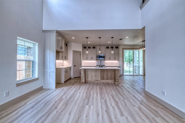 6 Rio Seco Dr, Uvalde, TX 78801 - kitchen with stainless steel microwave, light wood-style floors, light countertops, a high ceiling, and recessed lighting